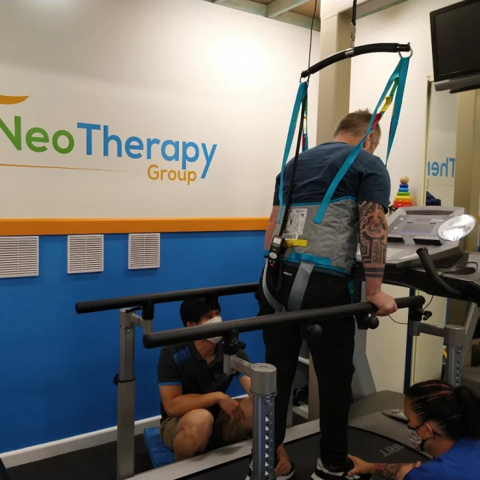 Man in harness walking on treadmill