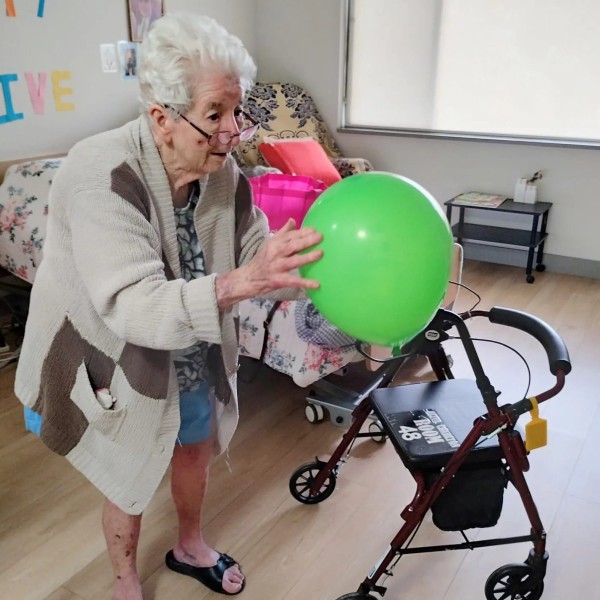Lady in aged care facility catching balloon